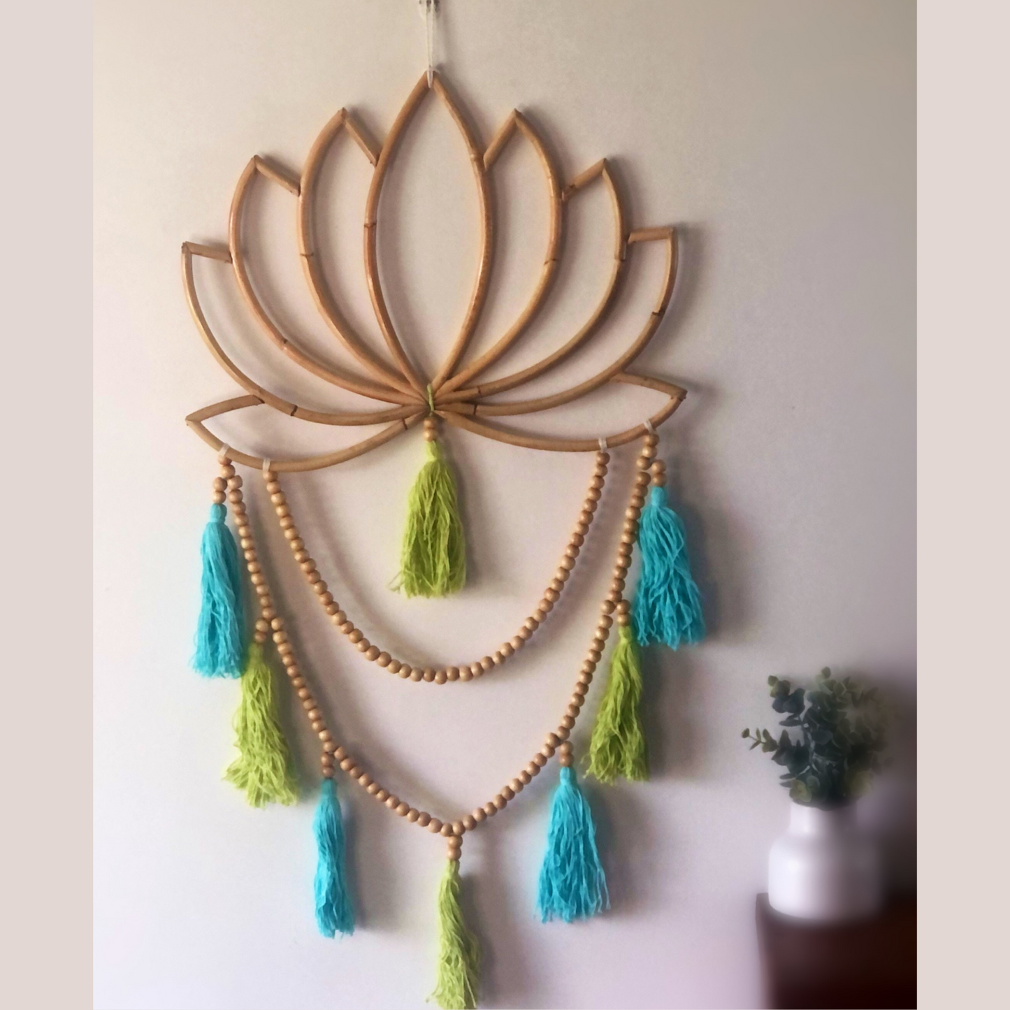 This beautiful design combines beads and tassels falling from a blooming lotus flower. Blue and green tassels.