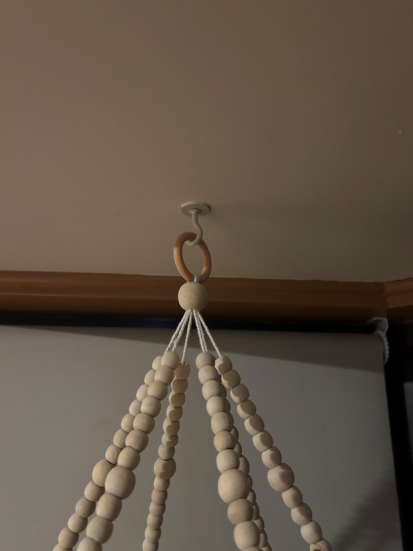 Wooden beaded holder hanging on a tassell mobile