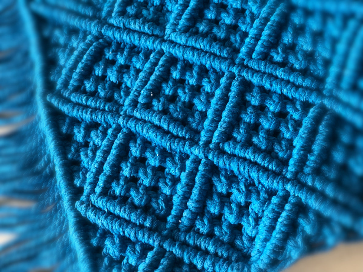 Close-up of teal blue macrame rectangle mat showing intricate diamond knot weave texture and fringe edge — handcrafted boho rug Australia