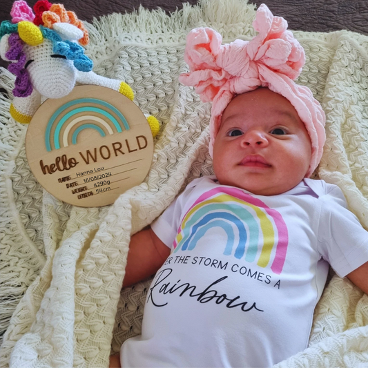 Wooden announcement disc with the text 'hello WORLD'  and a rainbow