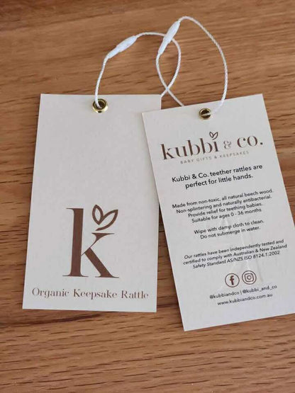 Kubbi & Co Wooden Teether Rattle product tag showing AS/NZS ISO 8124.1:2002 safety certification