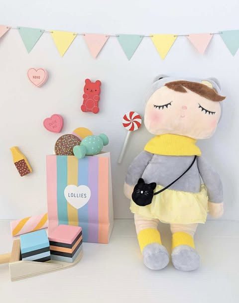 Plush doll toy dressed in yellow and grey outfit  with a small black cat bag 