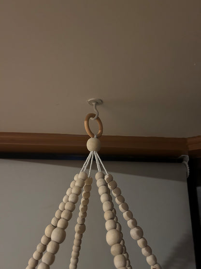Wooden beaded holder hanging on a tassell mobile