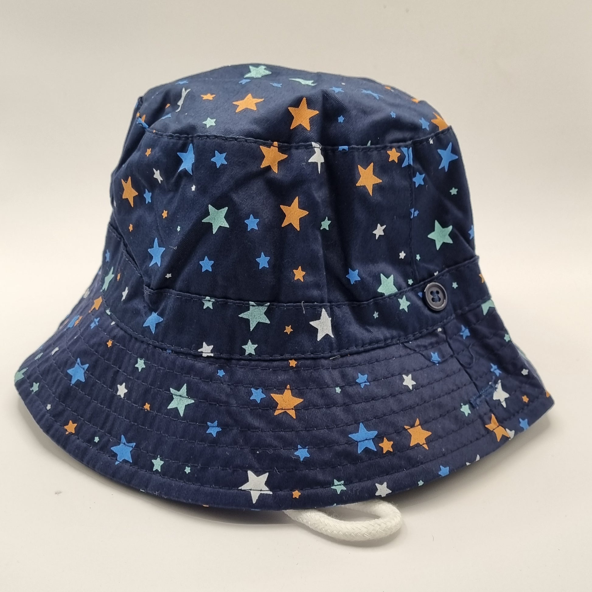 Navy blue bucket hat with colourful star pattern. Adjustable strap 
