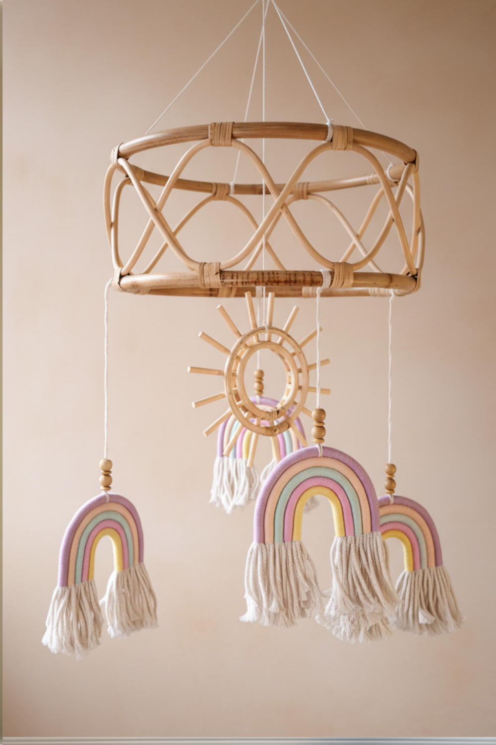 Close-up detail of boho rattan baby mobile showing blue macrame rainbow with cream tassels and wooden beads — large rattan mobile Australia