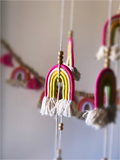 Pink, yellow and green design. Long mobile featuring rainbows and tassels